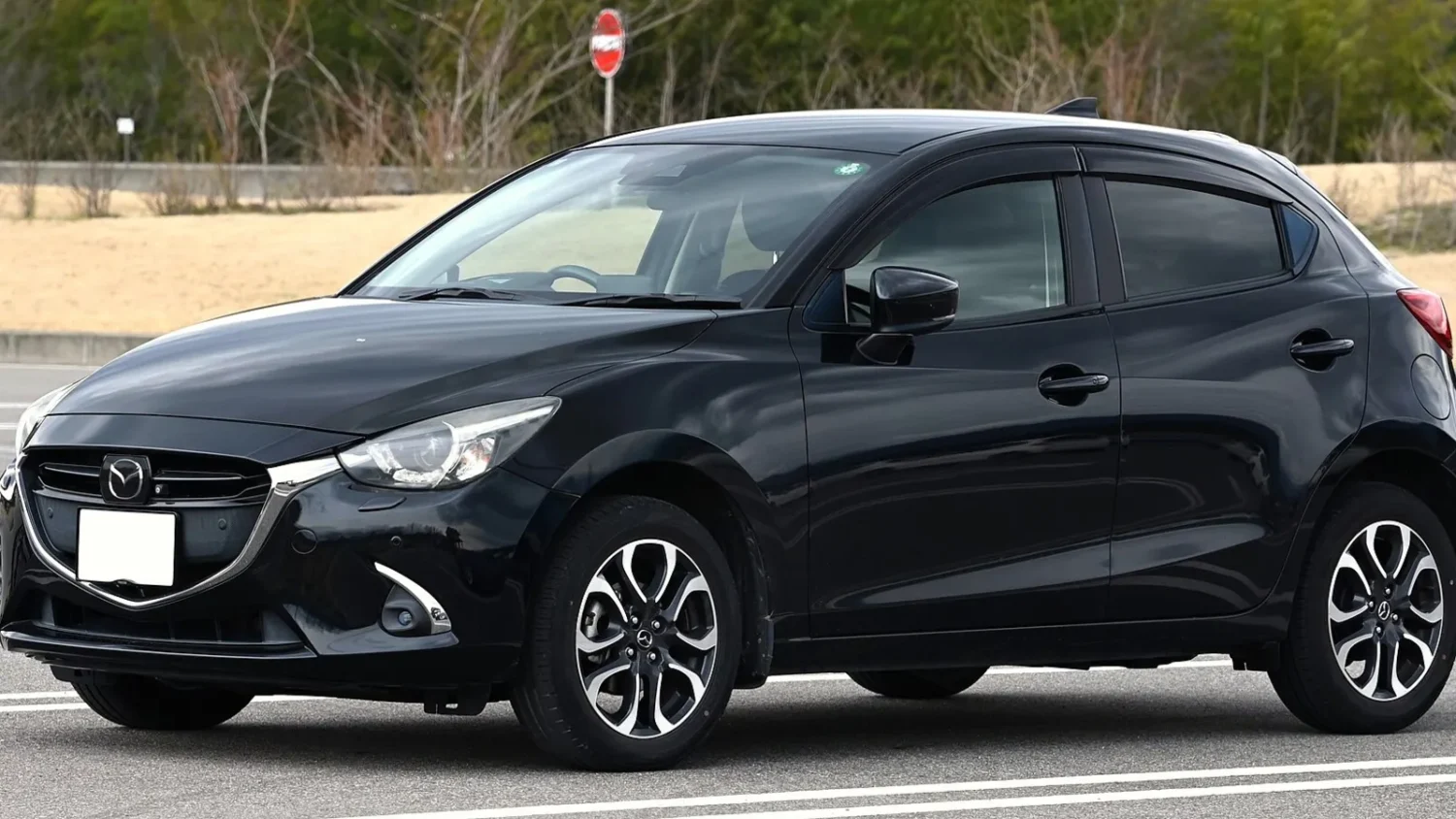 Чёрный хэтчбек Mazda на парковке