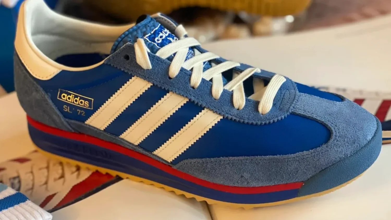 Синий кроссовок adidas с белыми шнурками