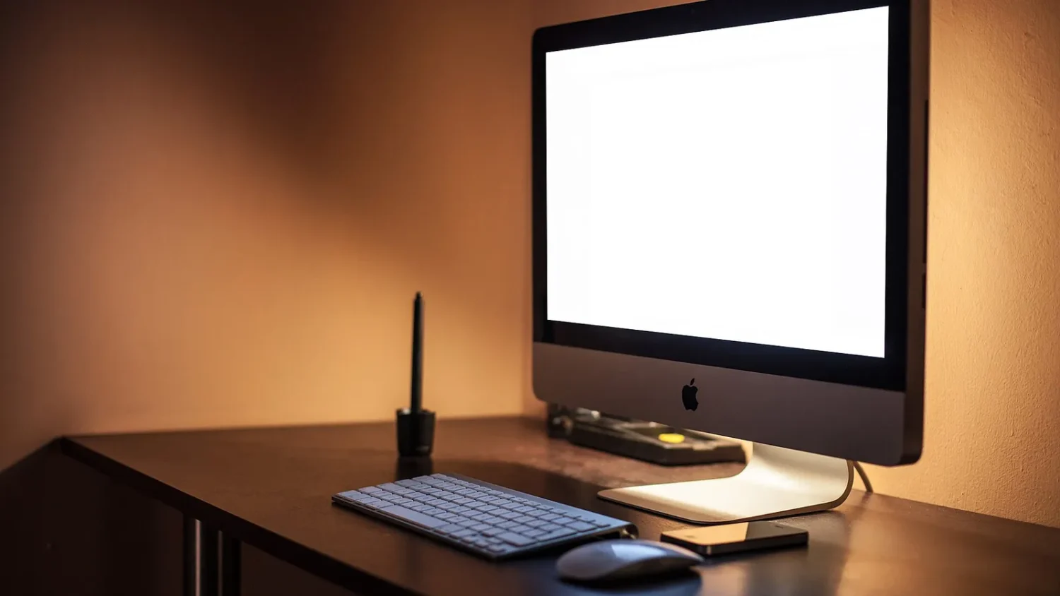 Моноблок iMac на столе в тёмной комнате