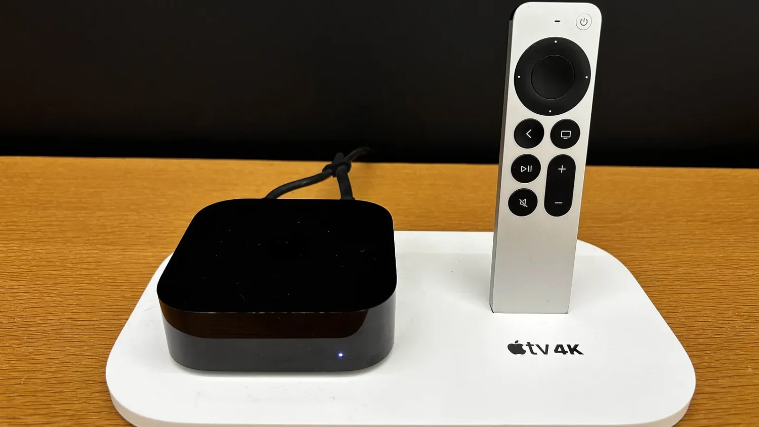 Приставка Apple TV и пульт Siri Remote на белой подставке