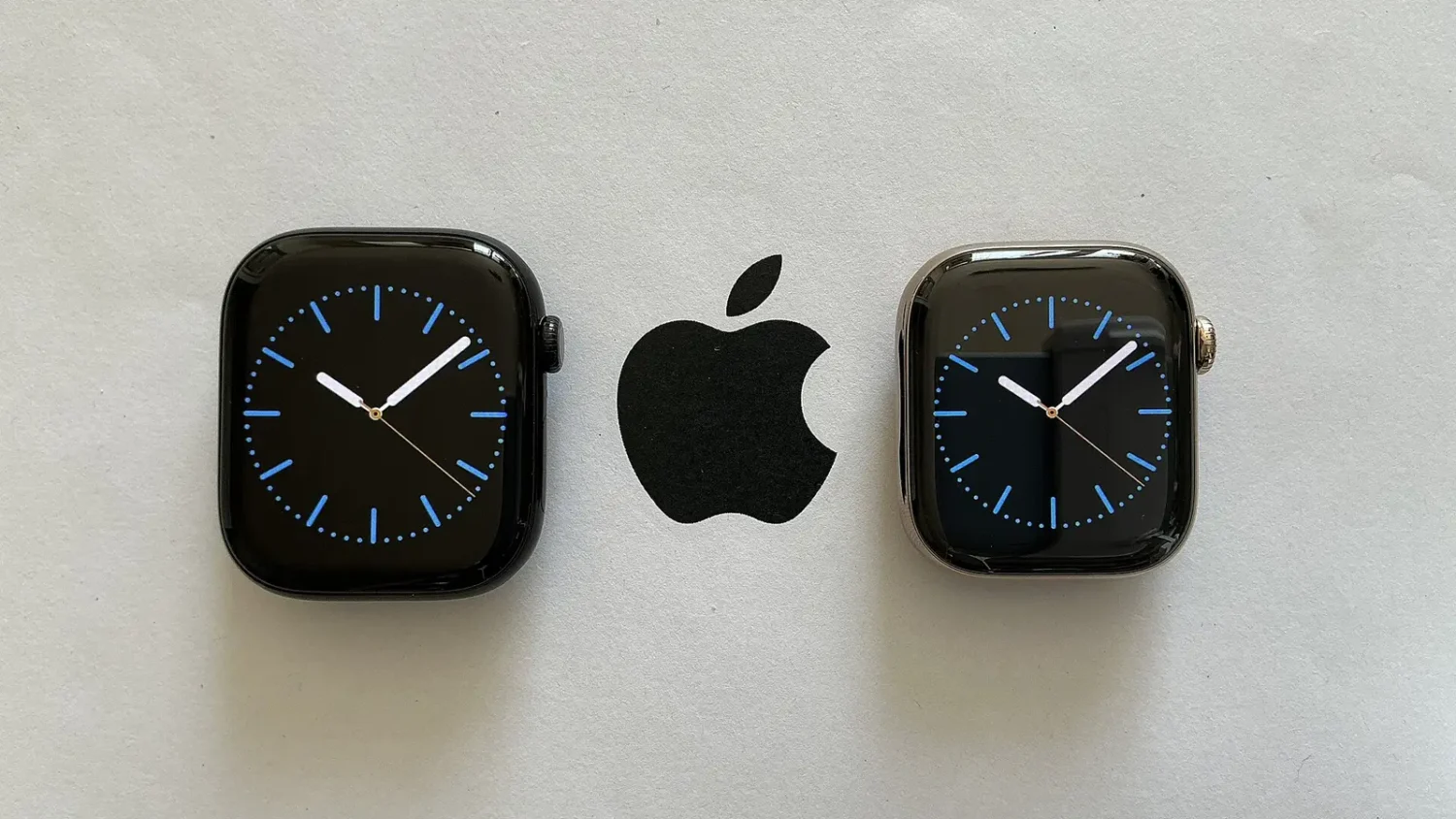 Двое смарт-часов Apple Watch и логотип Apple на сером фоне