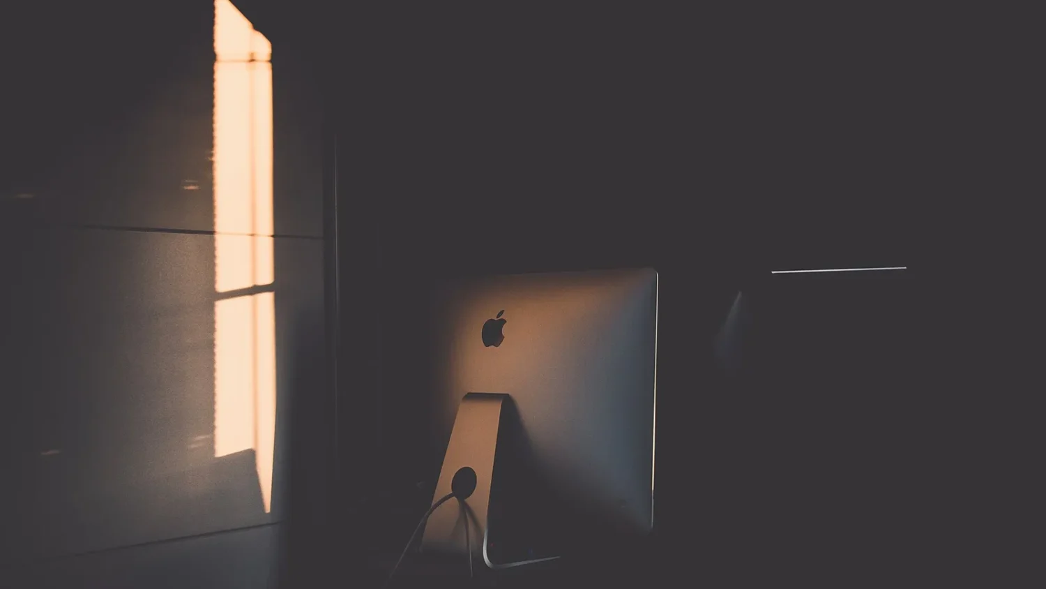 Моноблок iMac в тёмной комнате, вид сбоку