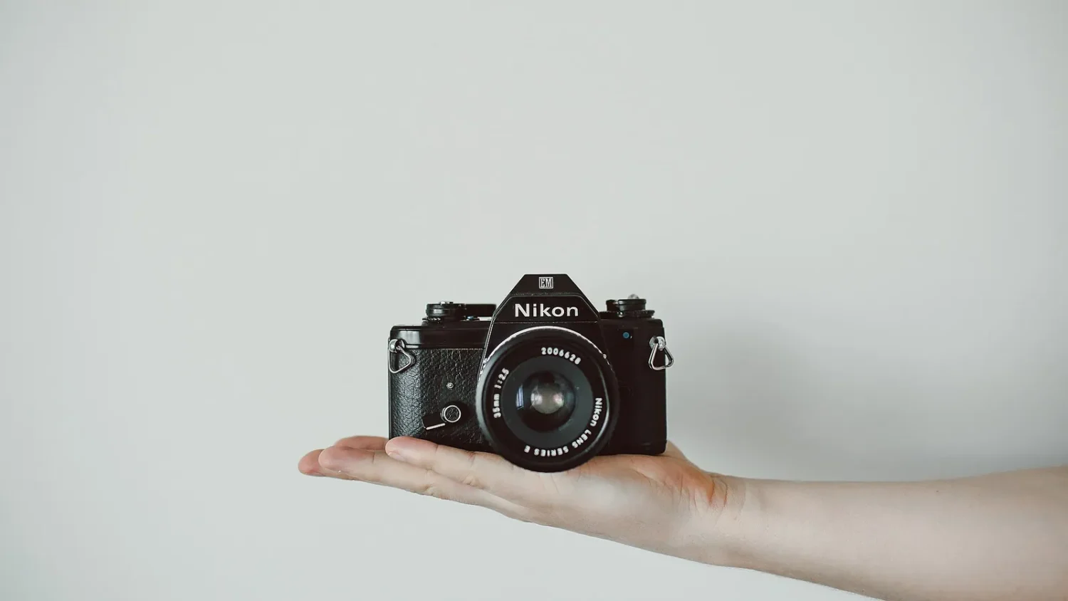 Фотоаппарат Nikon на раскрытой ладони