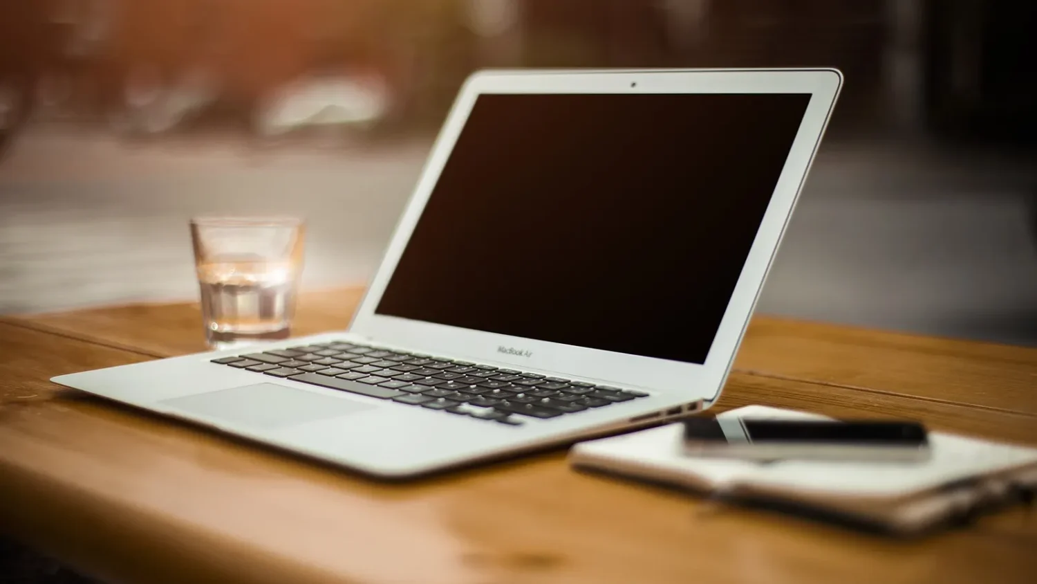 Ноутбук MacBook Air на деревянном столе в домашнем кабинете