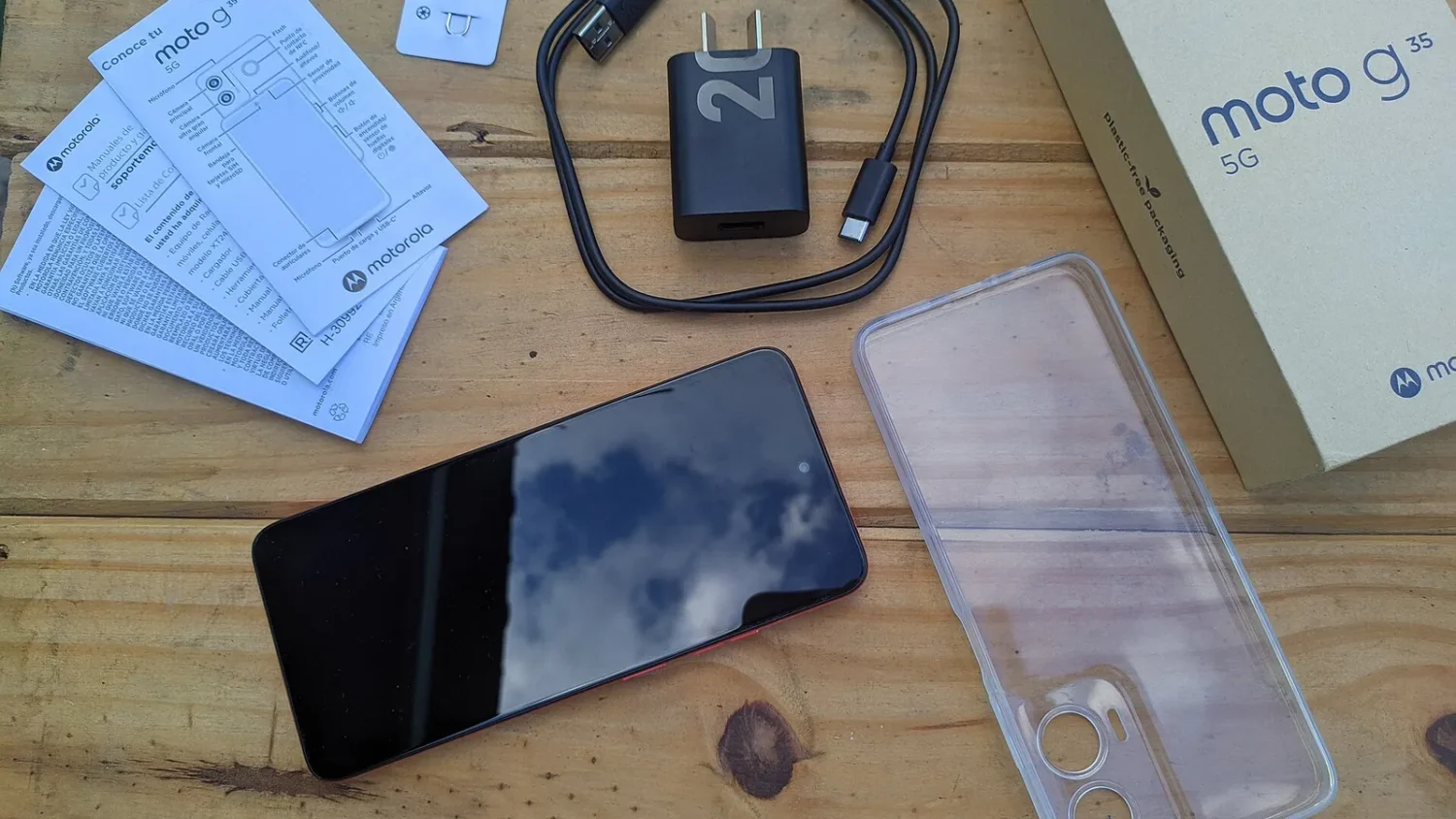 Смартфон Moto G и коробка от него на столе