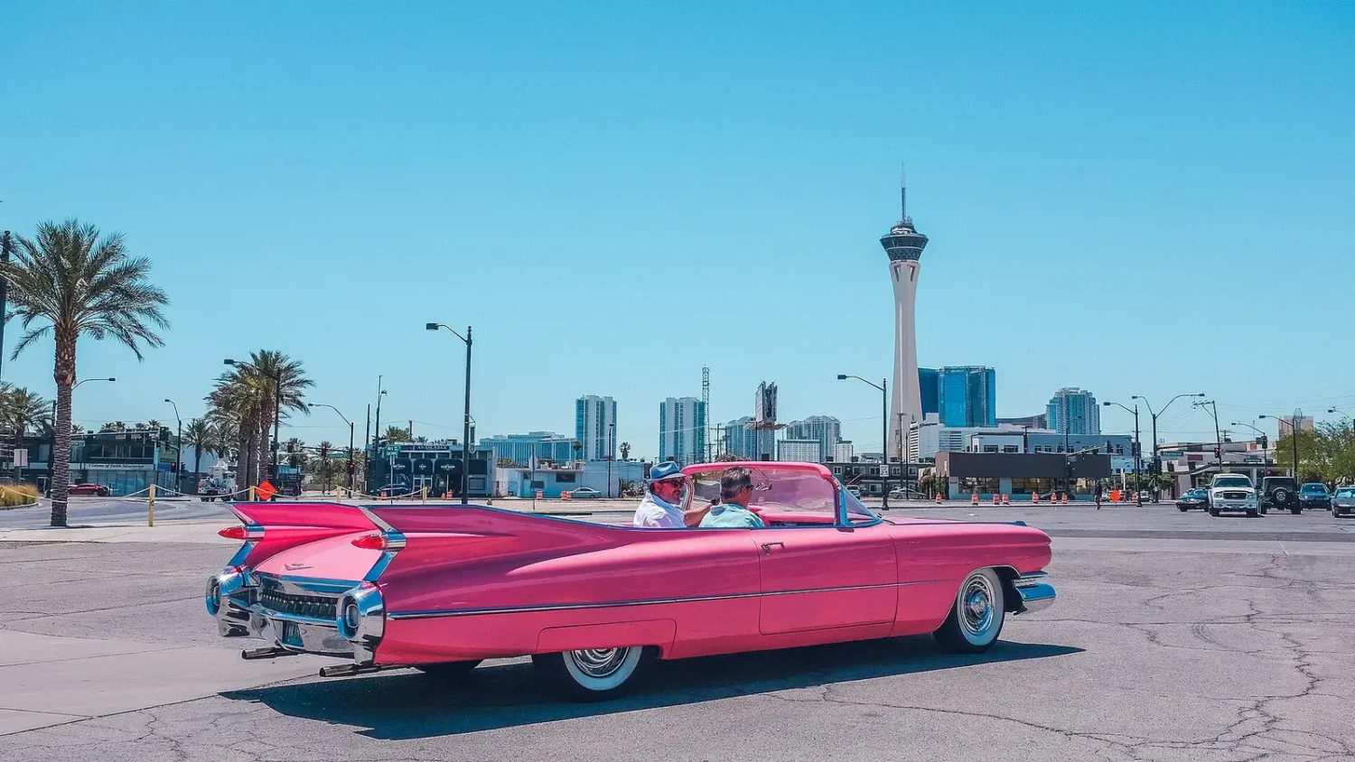 Розовый кабриолет Cadillac на улице на фоне небоскрёбов