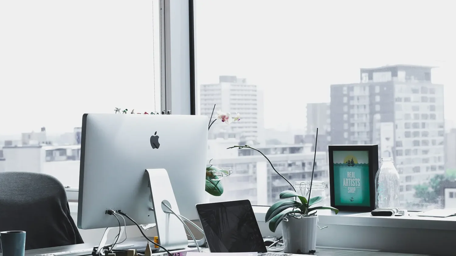 Рабочее место с iMac у окна с видом на город