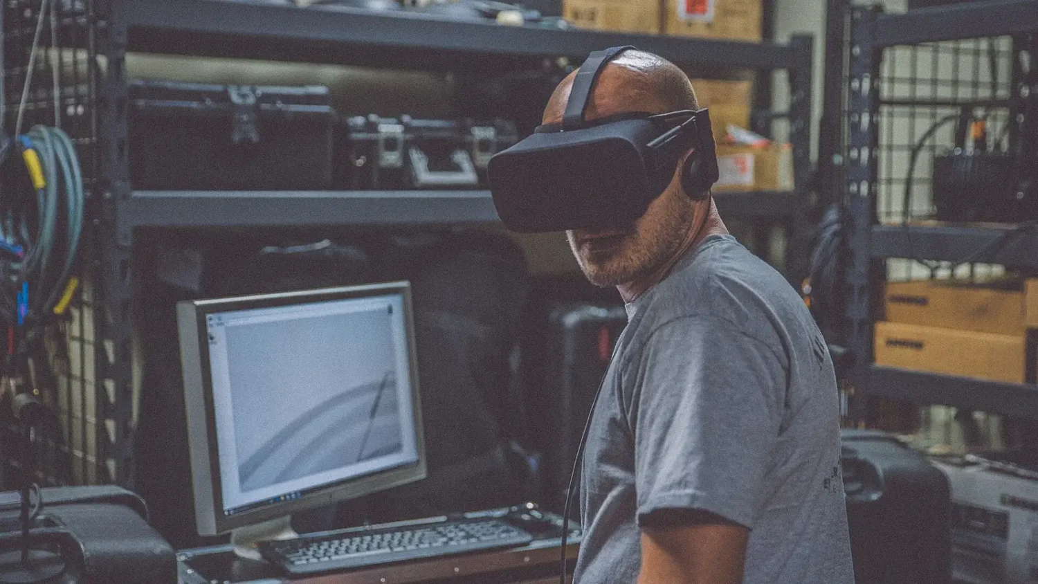 Мужчина в VR-шлеме в мастерской с компьютером